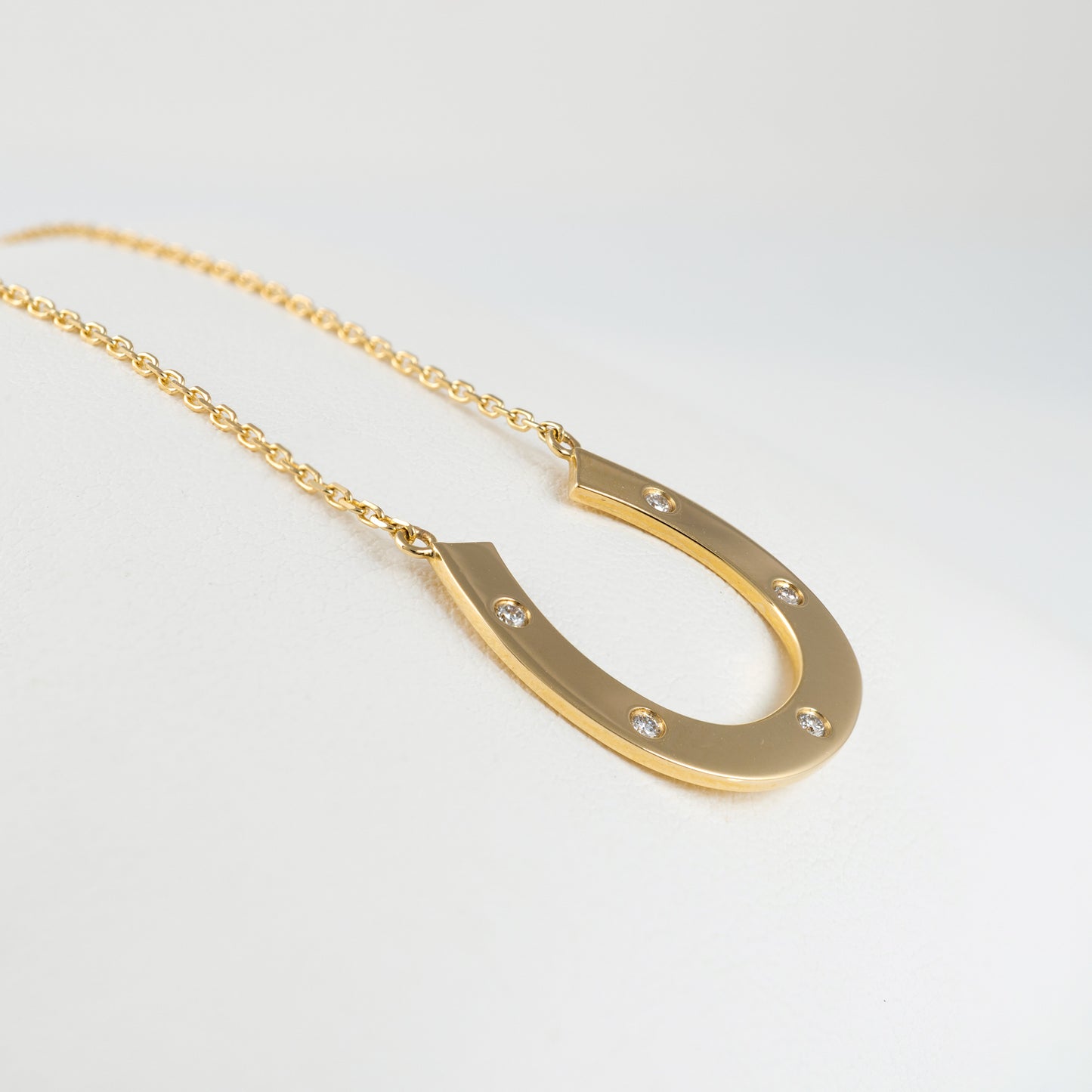 side view gold horseshoe necklace with diamonds