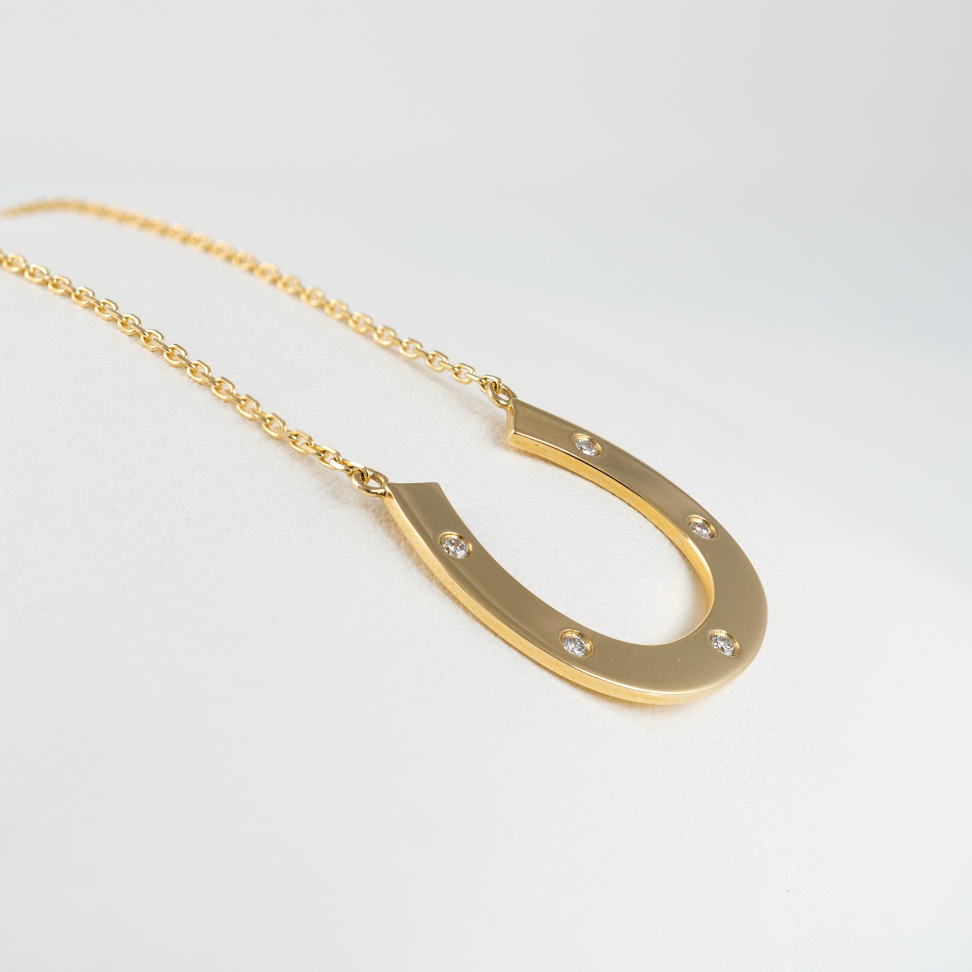 side view gold horseshoe necklace with diamonds