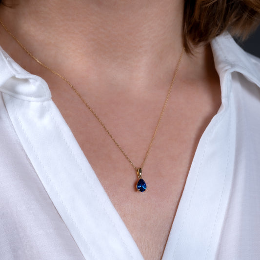 Gold sapphire necklace worn on model – teardrop pendant