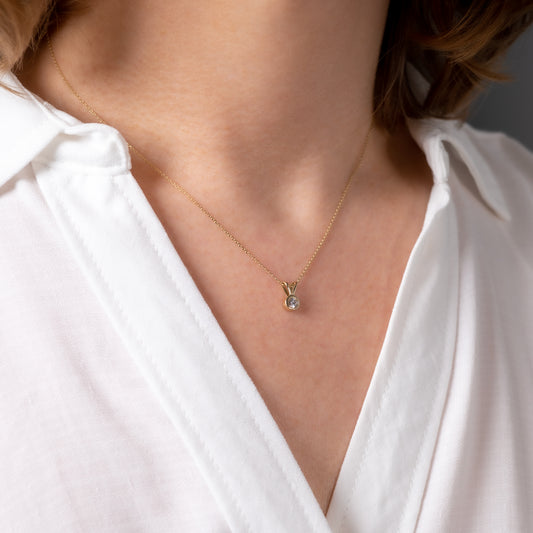 Close-up of woman wearing 9ct yellow gold lab-grown diamond V bale pendant necklace