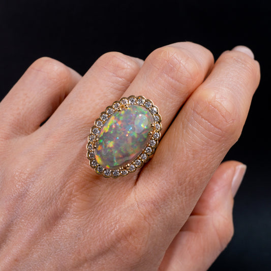 woman wearing opal ring gold and halo of diamonds