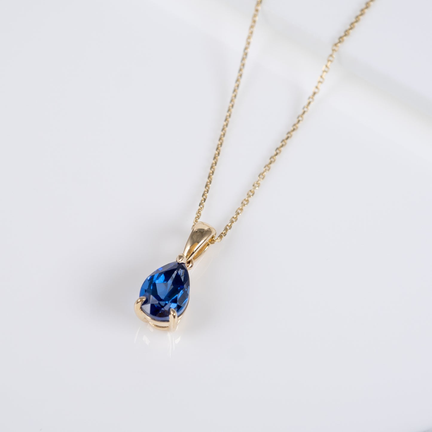 Teardrop sapphire pendant necklace in 9ct gold with chain – flatlay view