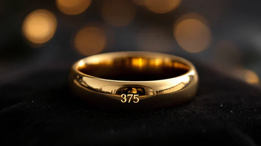 Close-up of a 9ct gold ring with a 375 hallmark, placed on a black velvet background with warm lighting