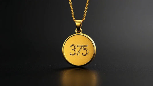 Gold pendant with '375' engraving on a dark background, symbolizing 9ct gold authenticity.