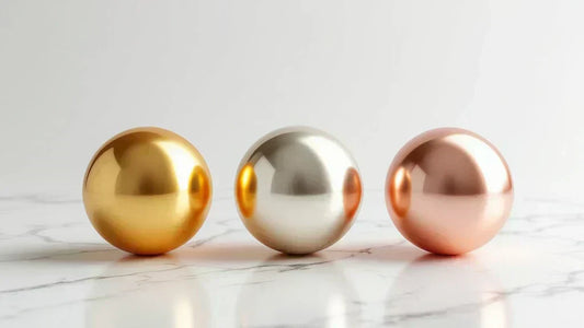 375 gold colours - yellow, white, and rose gold spheres on a marble background, showcasing the differences in hue and finish