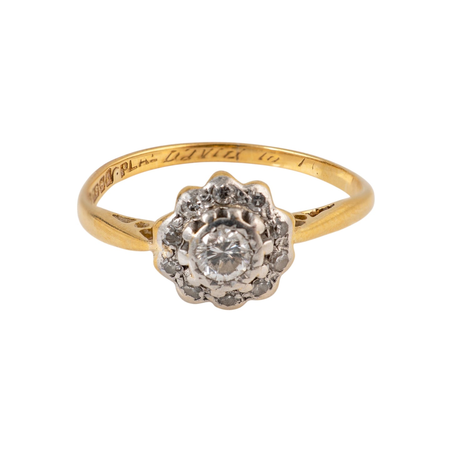A vintage diamond ring in yellow gold with a diamond cluster setting, featuring a central round diamond surrounded by smaller diamonds, on a plain white background.