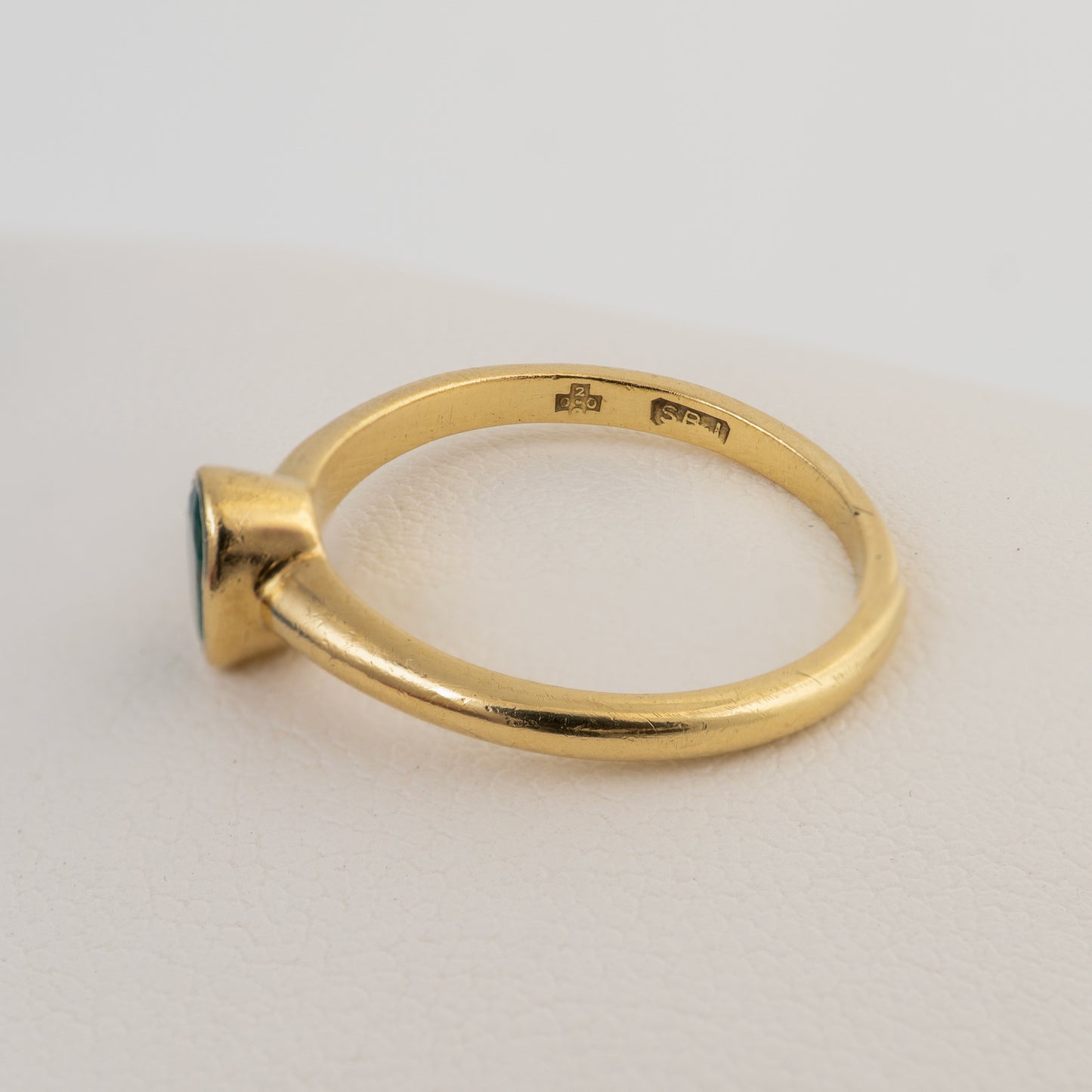 Hallmarked 18ct gold emerald solitaire ring showing the inside of the shank and hallmarks