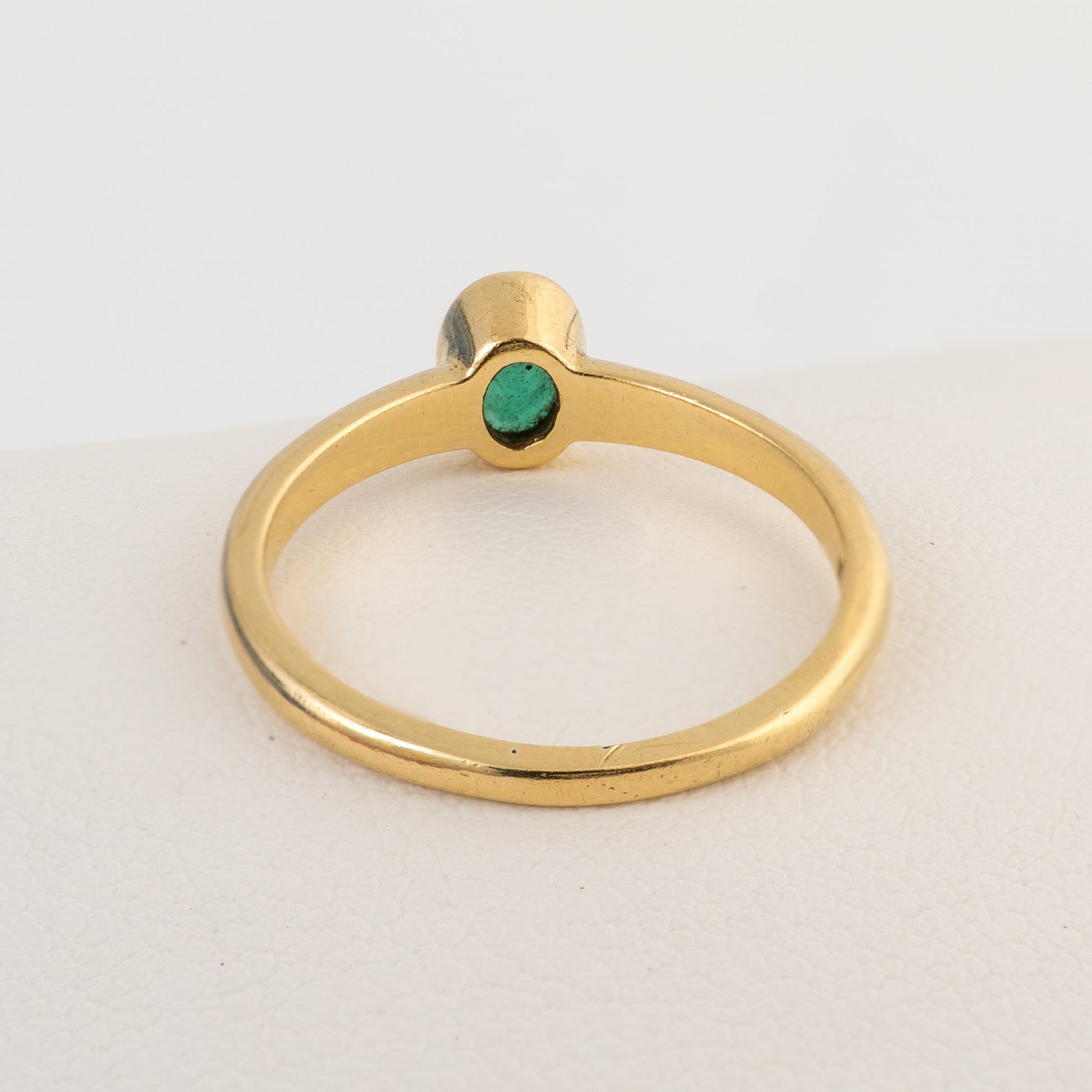 Rear view of an 18ct gold emerald solitaire ring showing the bezel setting