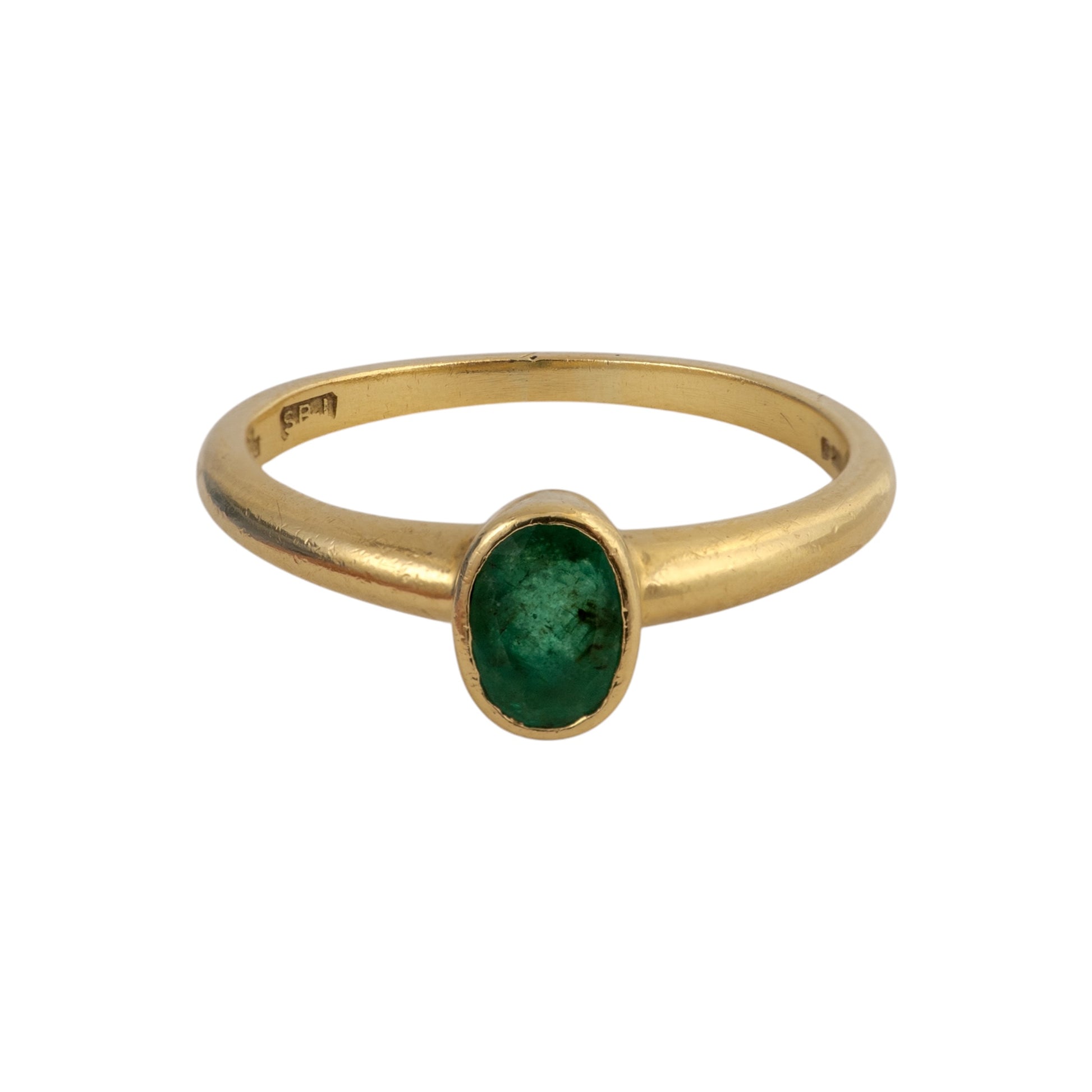 A yellow gold ring featuring an oval-cut green emerald gemstone in a bezel setting, shown against a plain white background.