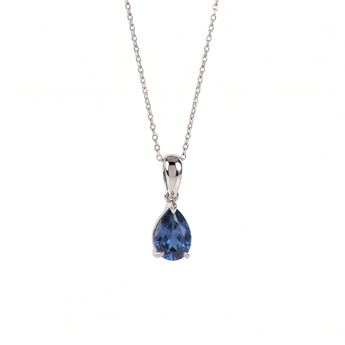 A silver pendant necklace featuring a teardrop-shaped blue gemstone in a prong setting, suspended from a delicate silver chain against a plain white background.