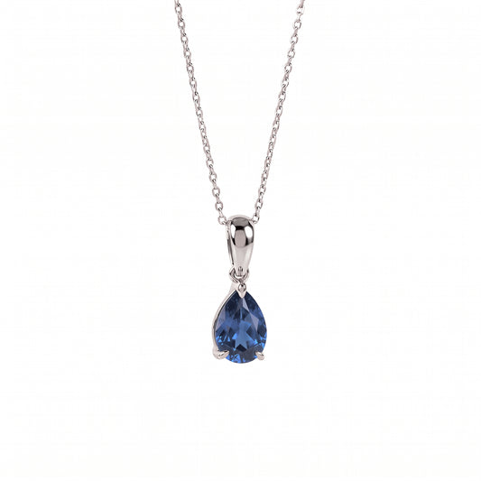 A silver pendant necklace featuring a teardrop-shaped blue gemstone in a prong setting, suspended from a delicate silver chain against a plain white background.