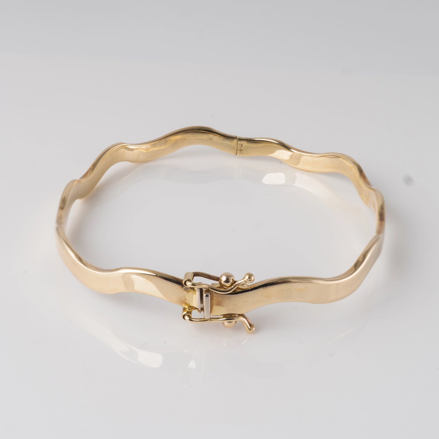 375 gold wave bangle bracelet – close-up of safety clasp and hinged design.