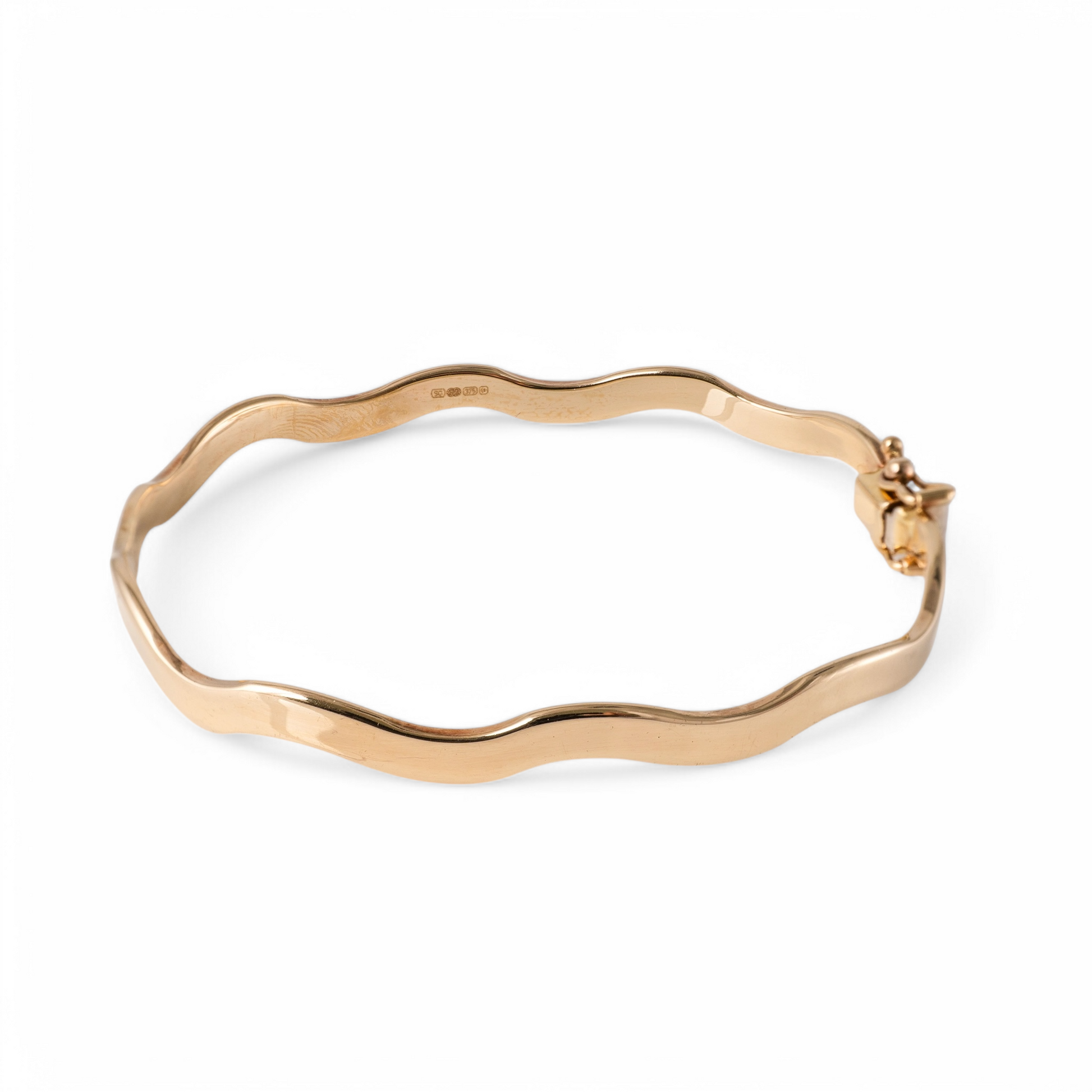 375 gold wave bangle bracelet – hallmarked hinged design on white background.