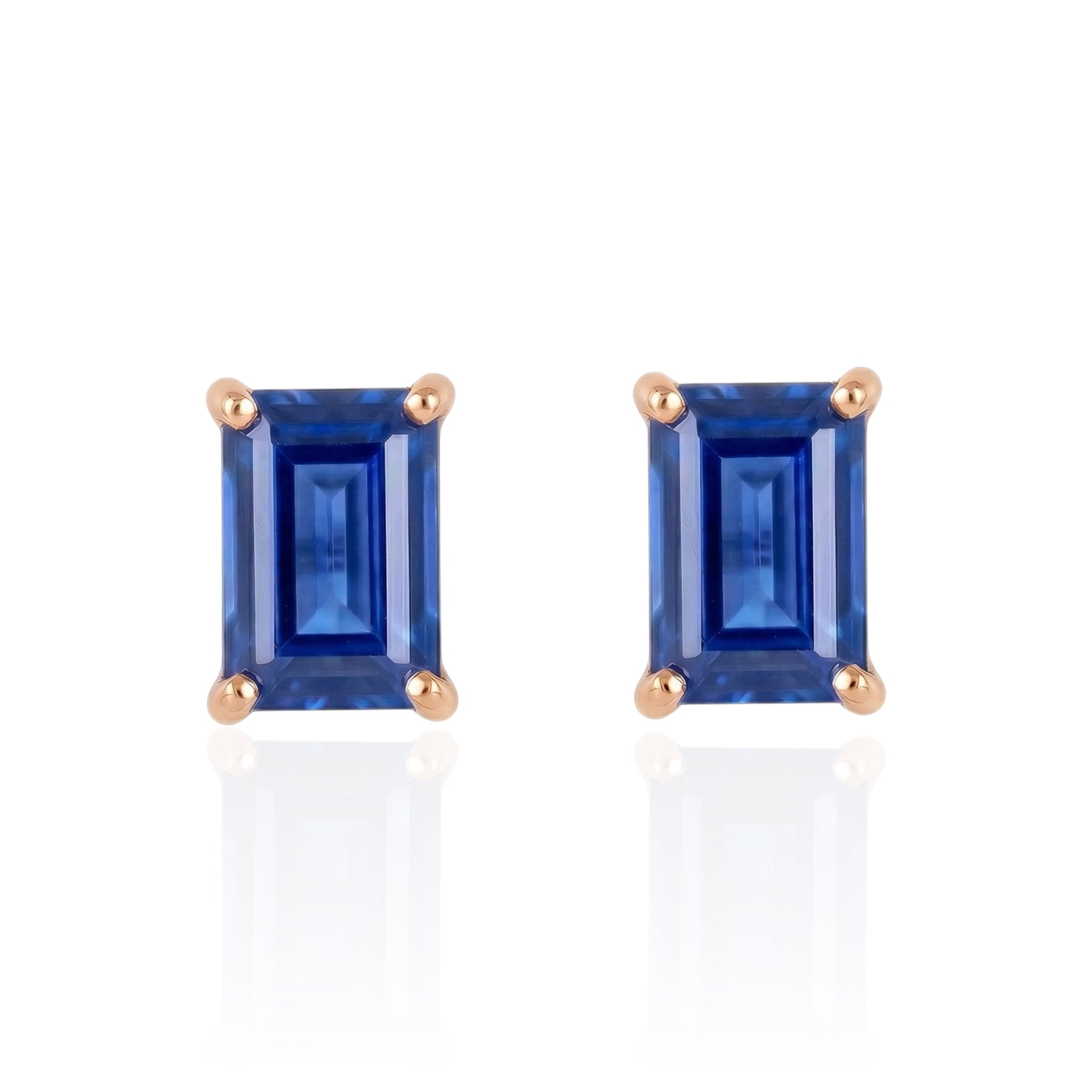 Pair of blue lab sapphire studs earrings earrings with rose gold settings on a white background