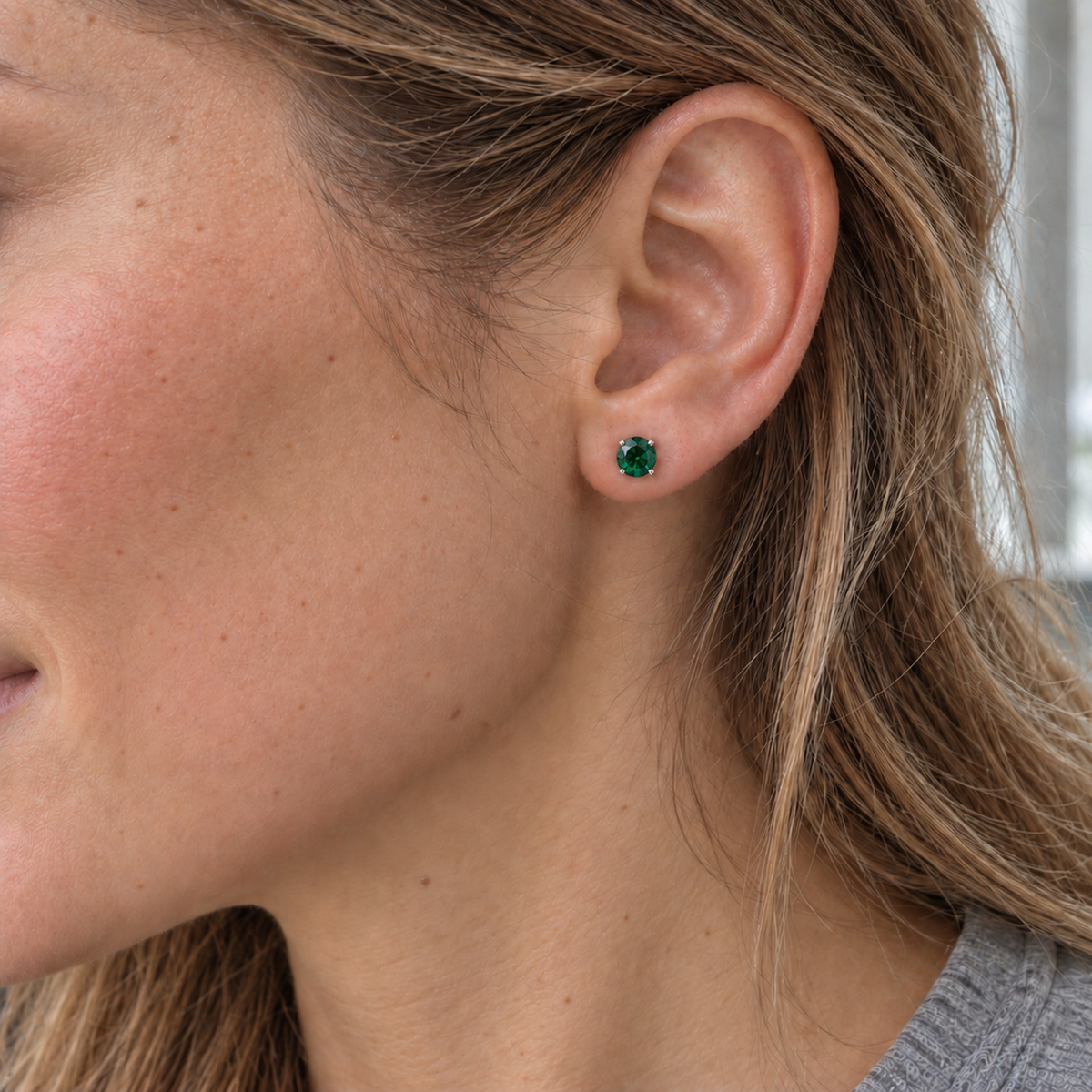 5mm round lab emerald stud earring in sterling silver worn on the ear