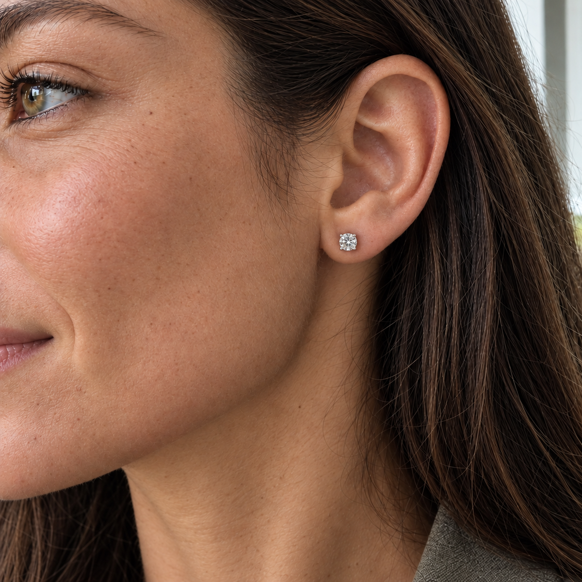 AI visualisation of a model wearing a 5mm moissanite stud earring in rhodium-plated sterling silver.