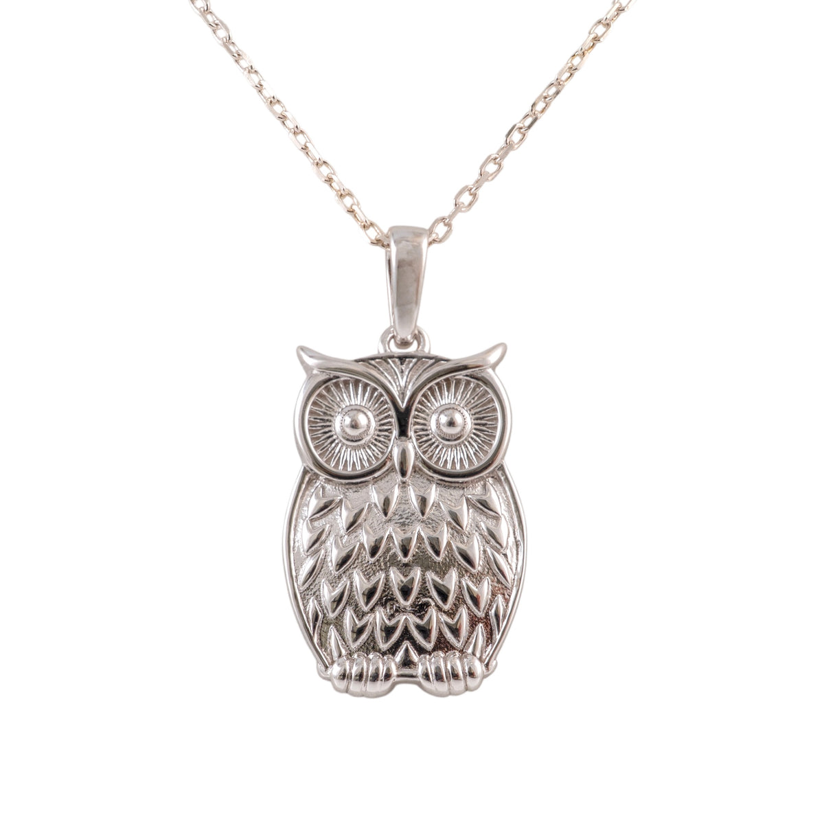 A plain silver owl pendant necklace with detailed feather and eye engravings, hanging from a delicate silver chain against a plain white background.