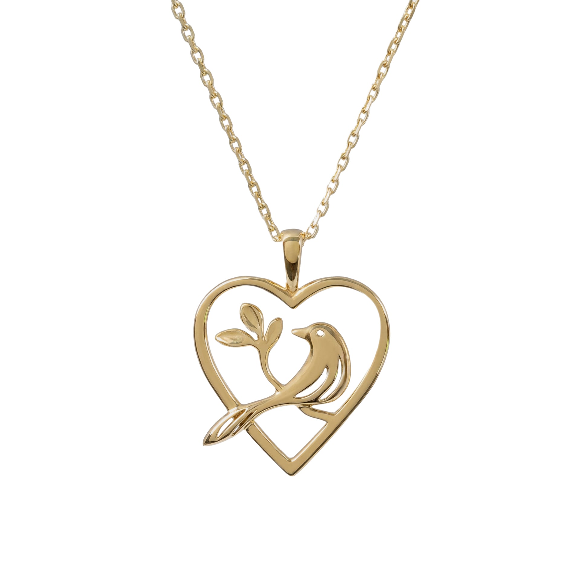 A gold necklace featuring a heart-shaped pendant with a bird perched on a branch, shown against a plain white background.