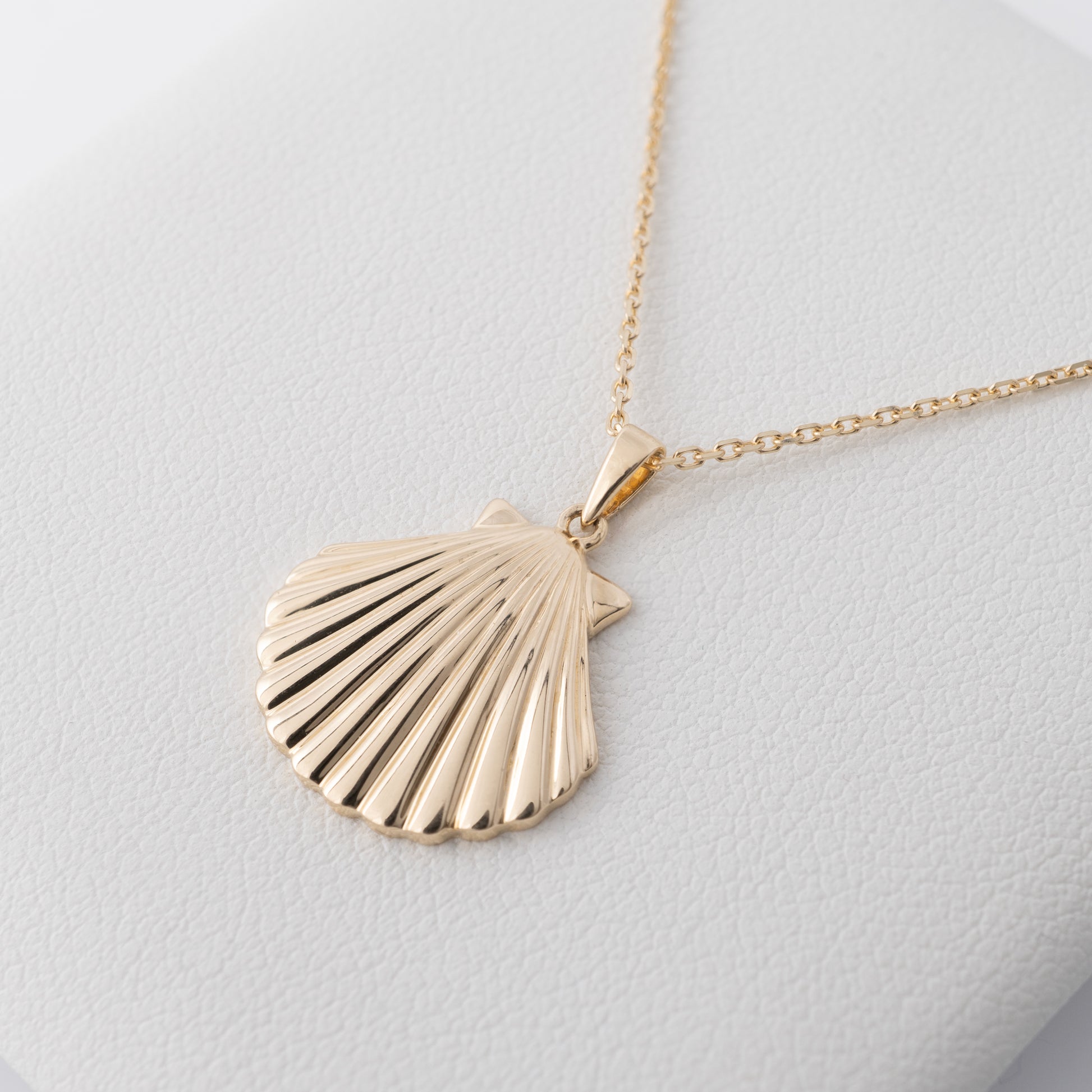 Close-up of the gold shell necklace pendant texture and detail