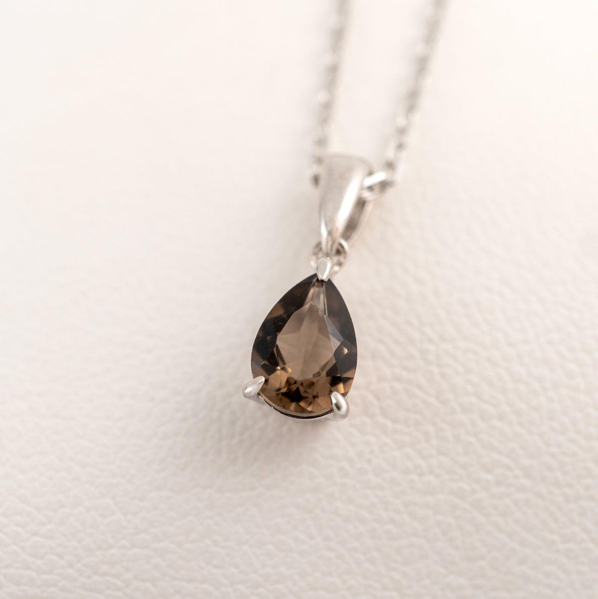 Close-up of the natural pear-cut smoky quartz gemstone in its sterling silver pendant setting.