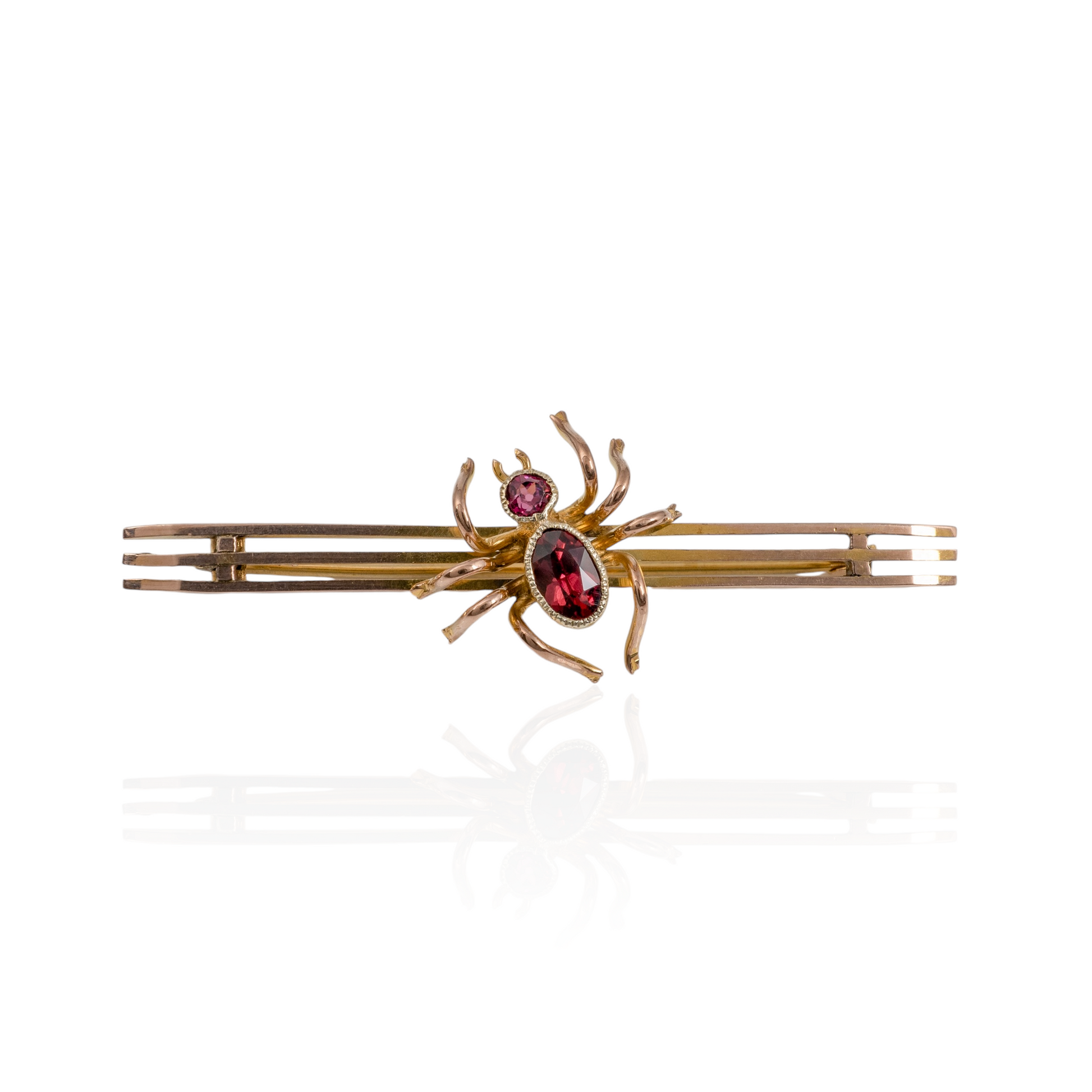 Front view of antique spider brooch in 9ct gold with red garnet gemstones