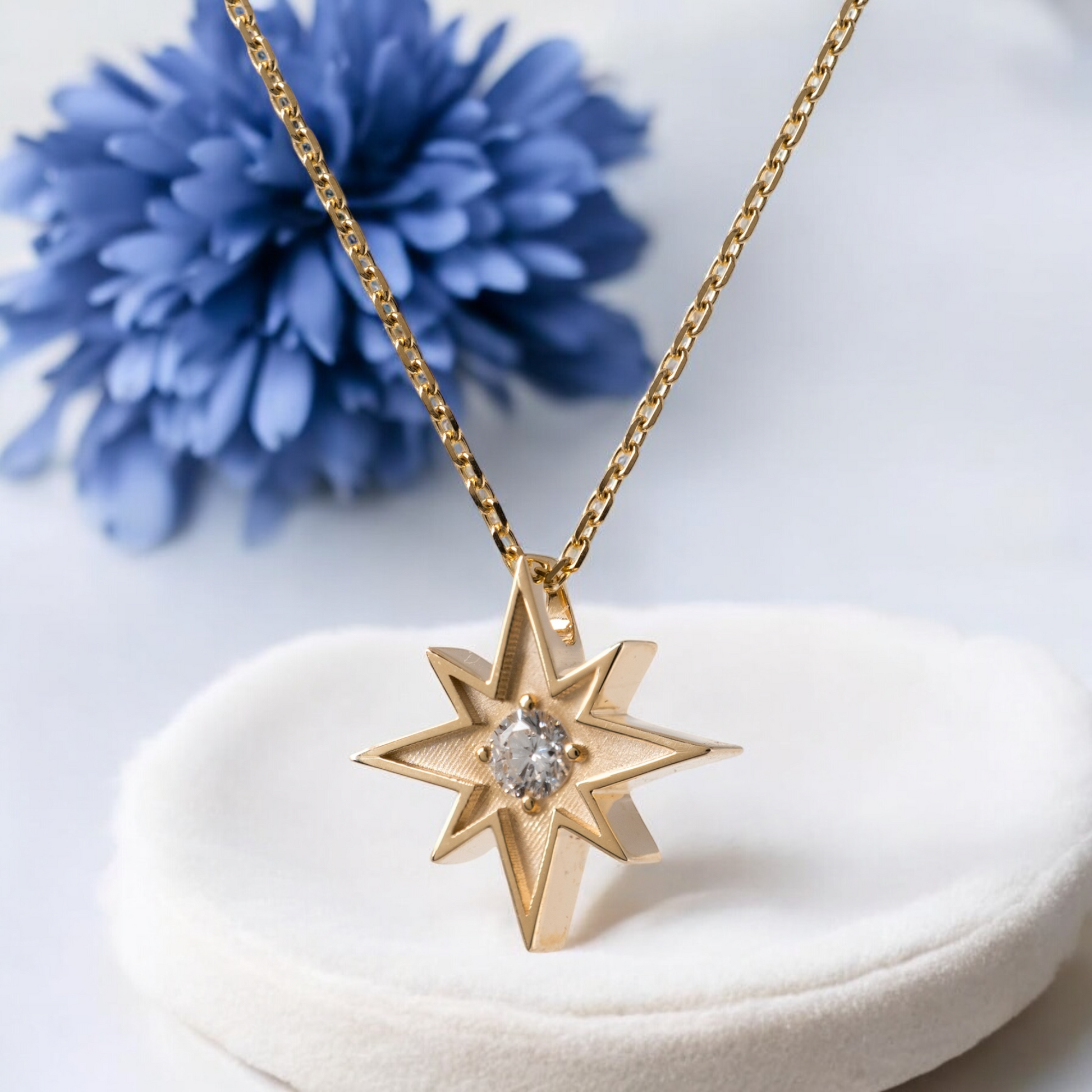 Gold North Star necklace with lab diamond and blue flower background – Hunters Fine Jewellery