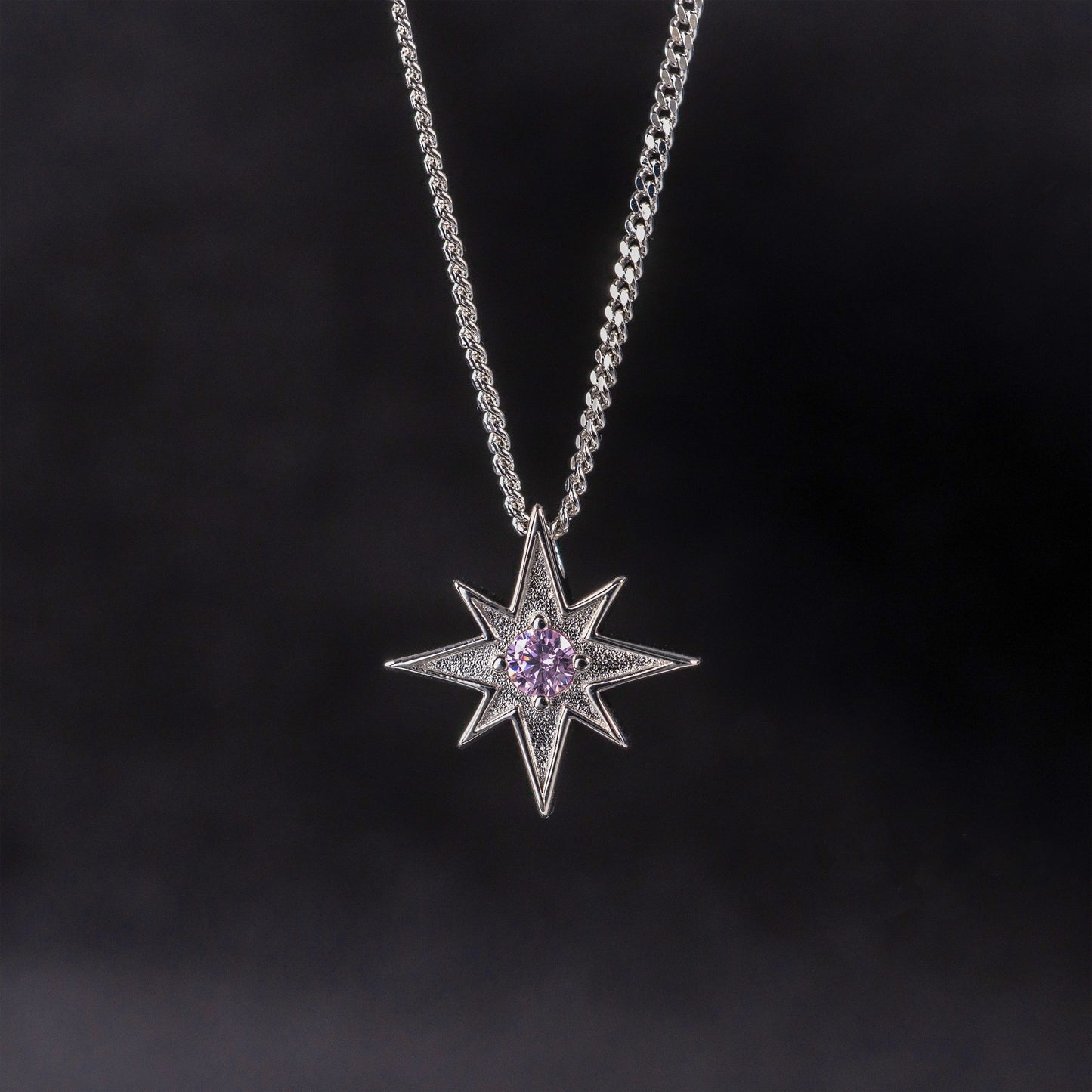North Star necklace in silver with pink gemstone against dark background