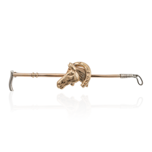 Front view of vintage horse brooch with riding crop design