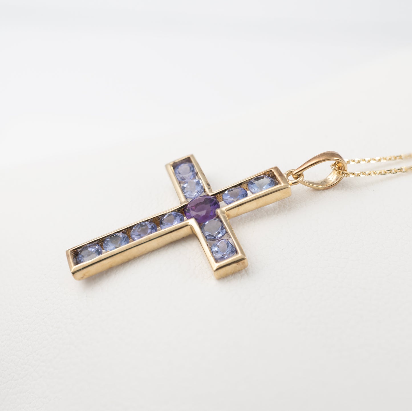 9ct gold crucifix necklace with vibrant tanzanite and amethyst side view