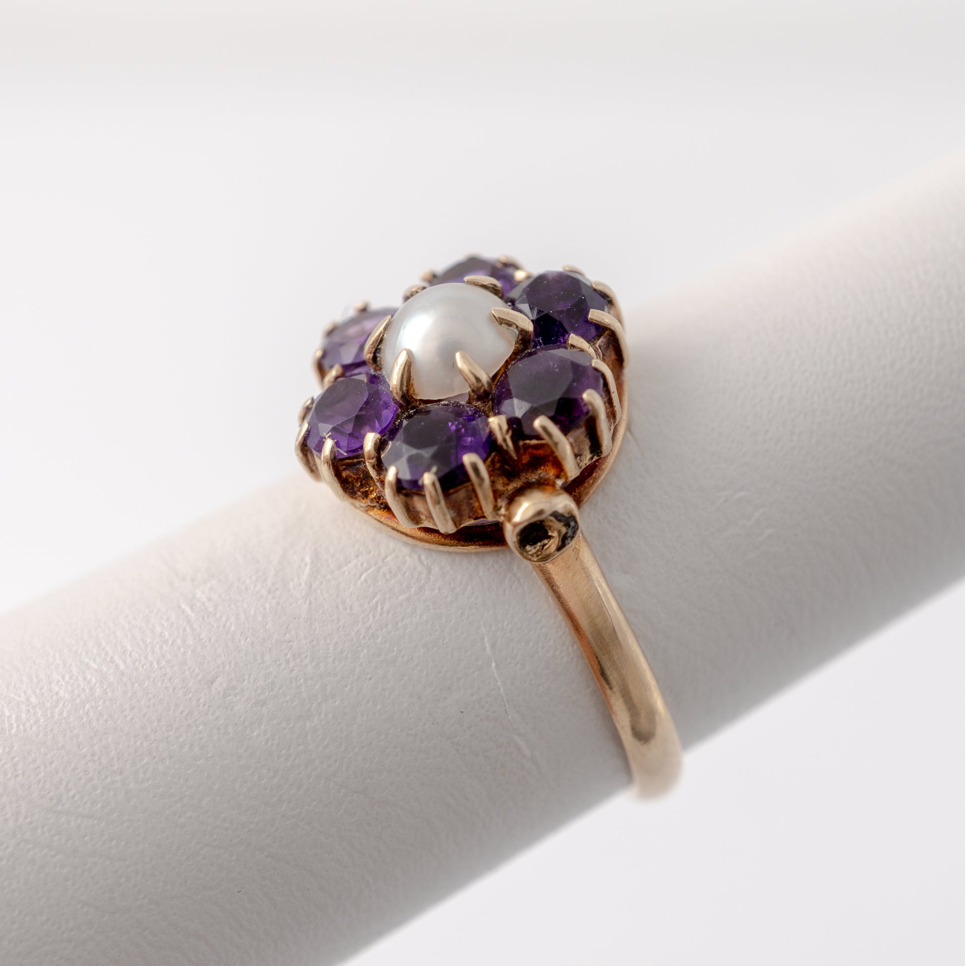 close up side view of vintage amethyst and pearl flower ring in 9ct yellow gold.