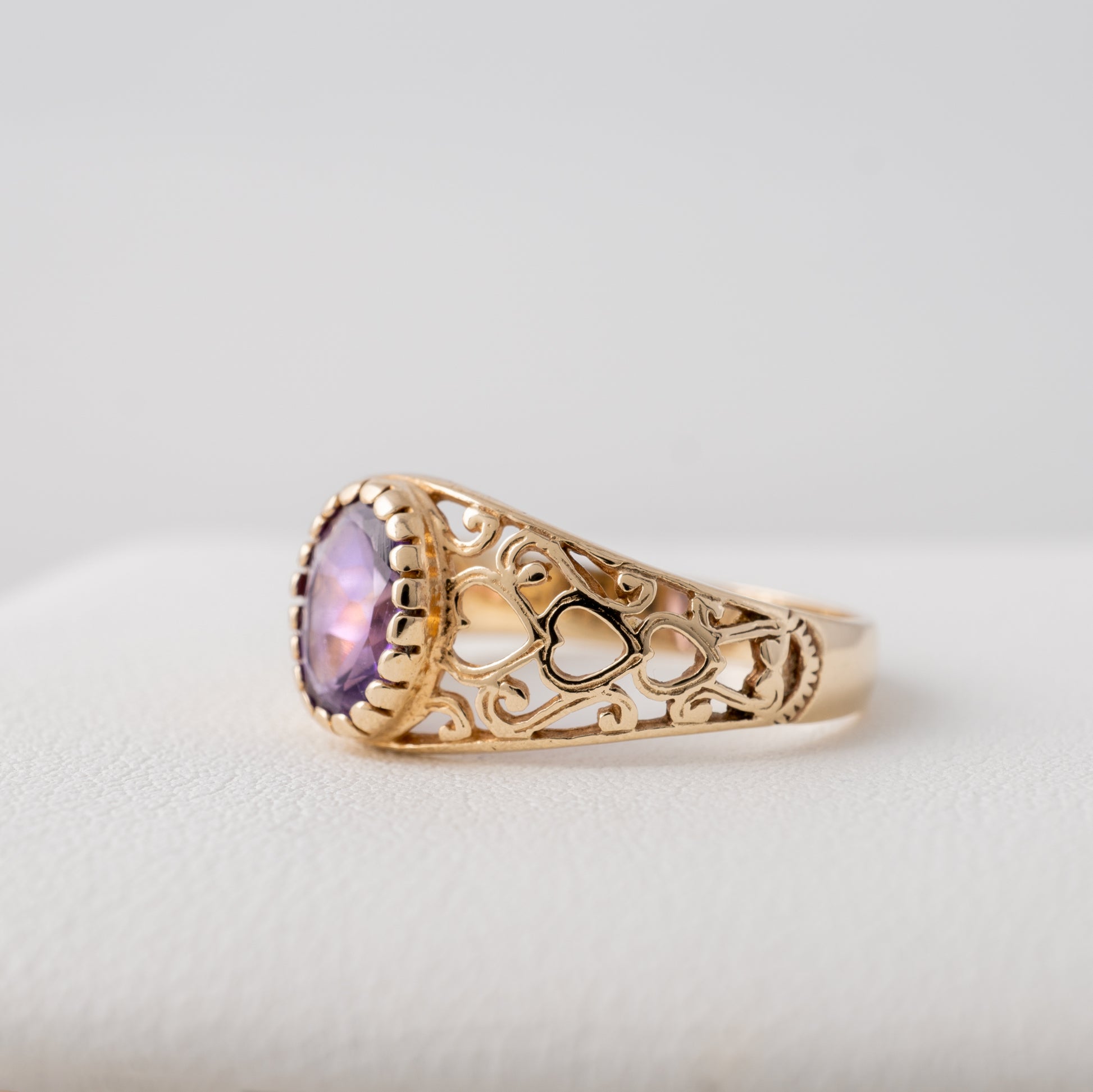 Amethyst ring with open-cut heart motifs on the side, 9ct gold February birthstone jewellery.