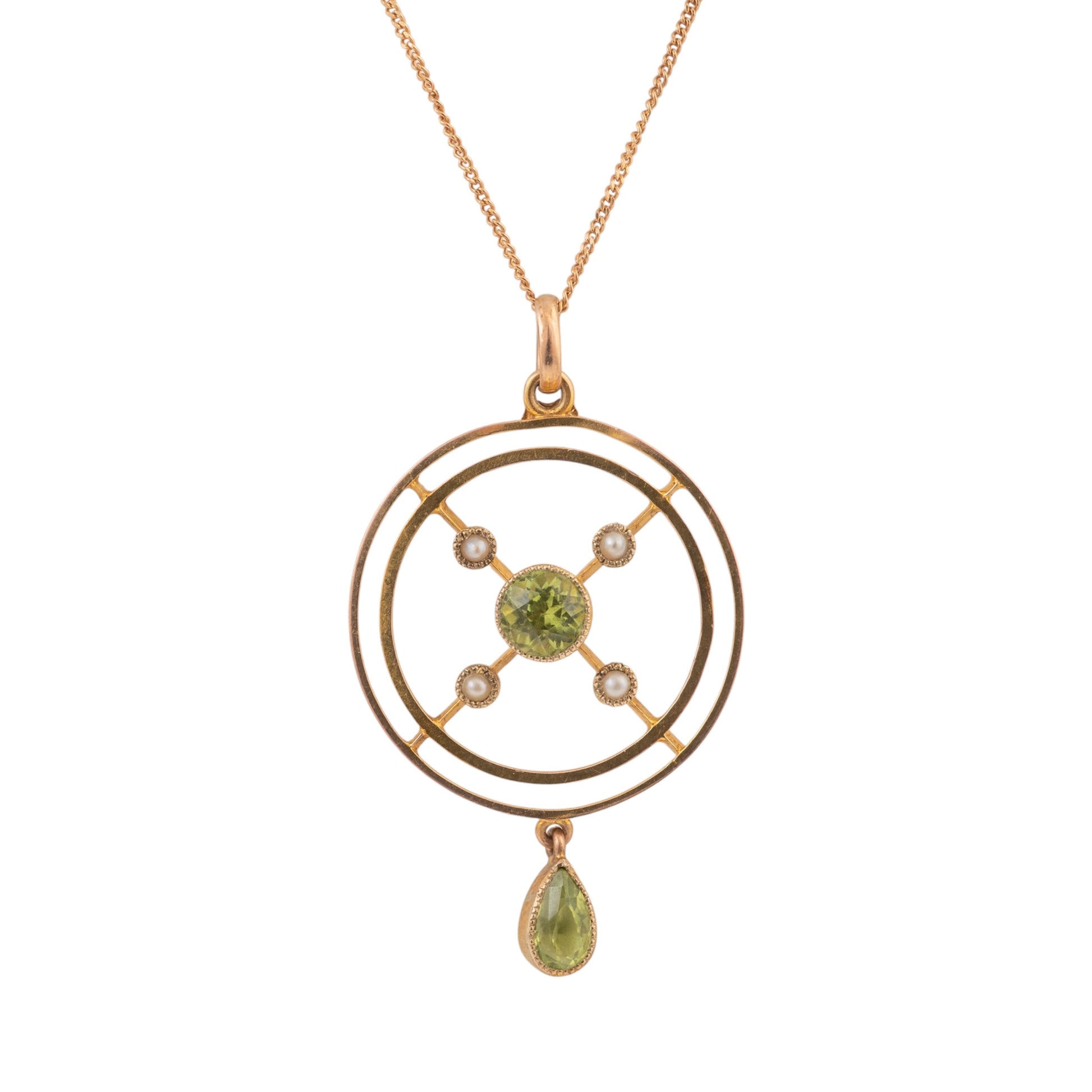 A gold pendant necklace featuring a circular geometric design with a central green peridot gemstone, small clear accent stones, and a dangling teardrop-shaped green gemstone, shown on a plain white background.