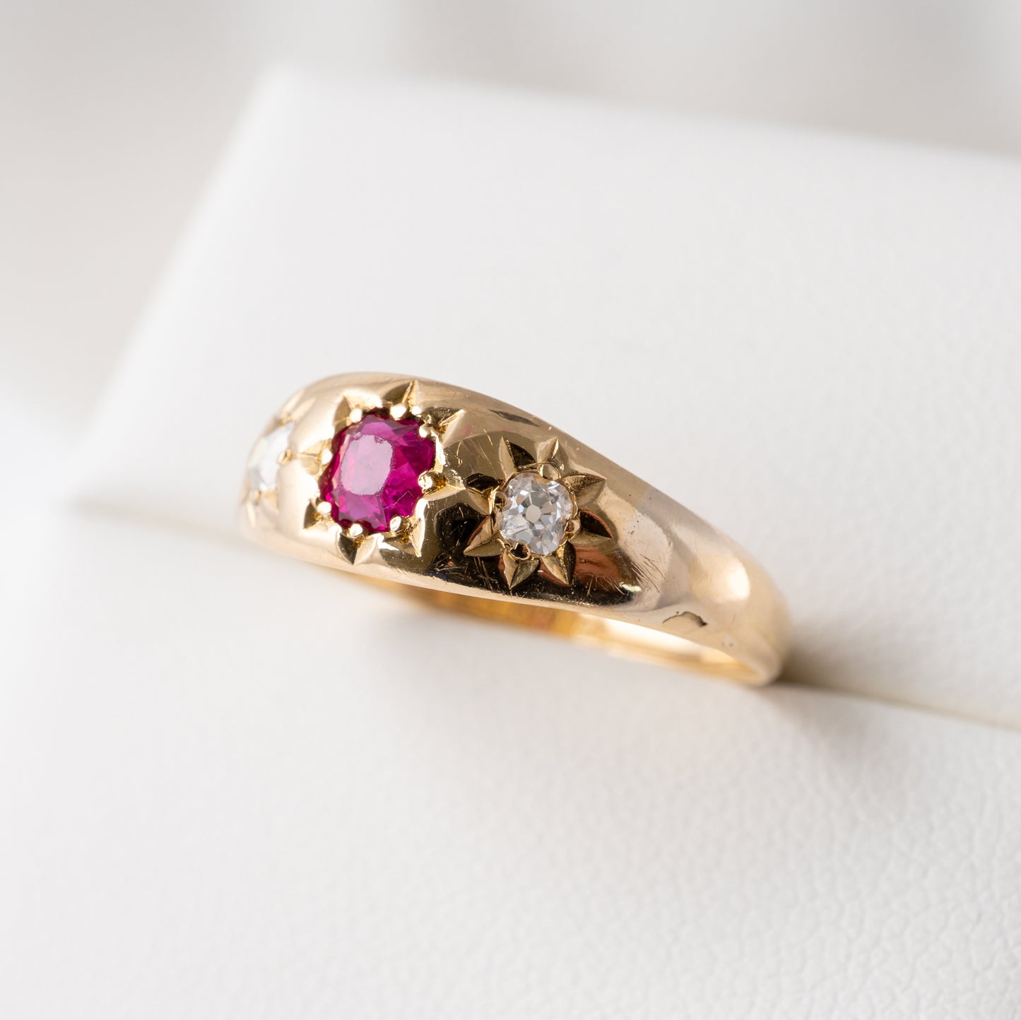 Close-up of an antique ruby and diamond gypsy ring in 18ct gold, showcasing celestial star-set gemstones