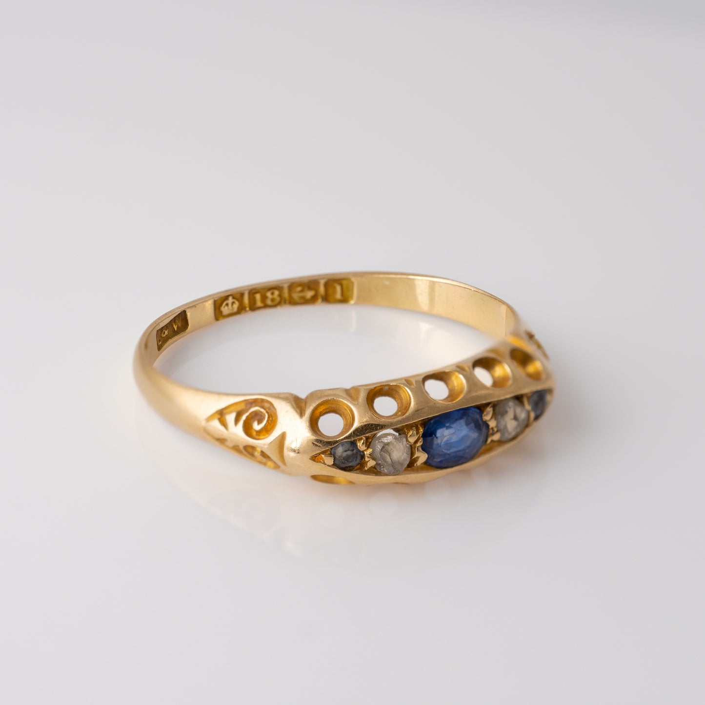 Slight side view of Edwardian sapphire and diamond ring with hallmarks.