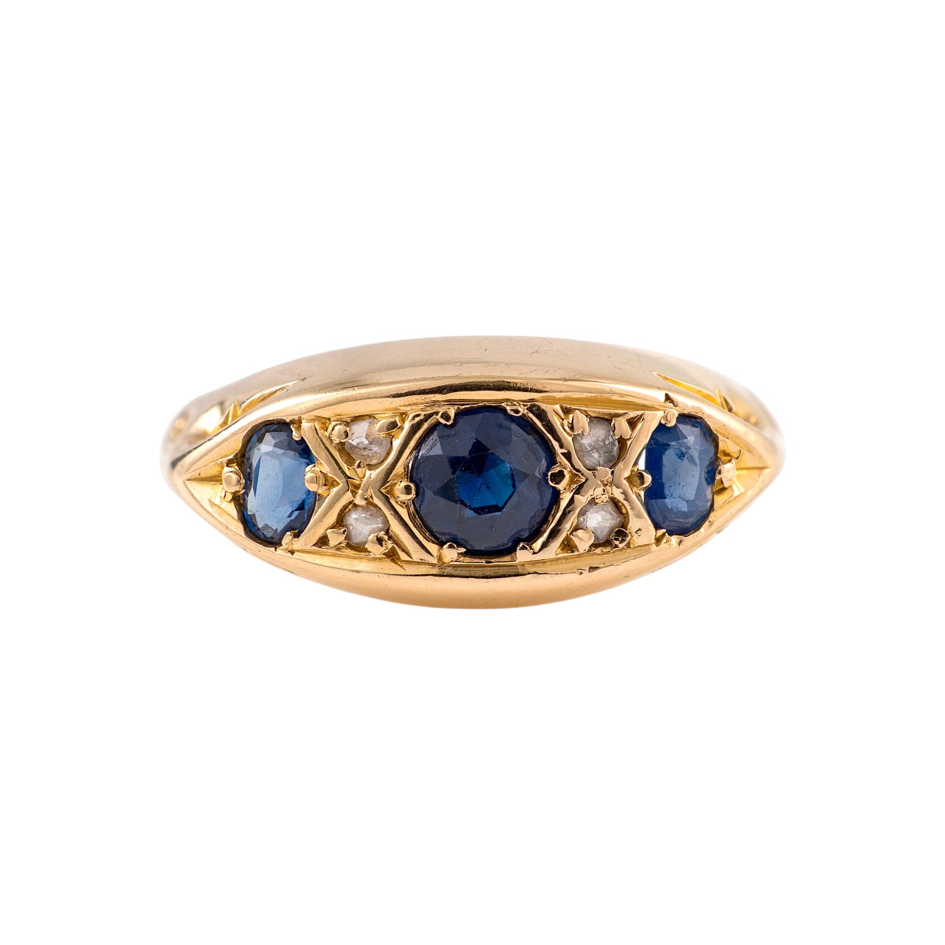 An antique sapphire ring featuring a central round blue sapphire flanked by smaller blue sapphires and tiny clear diamonds, set in an elongated marquise-shaped bezel on a white background.