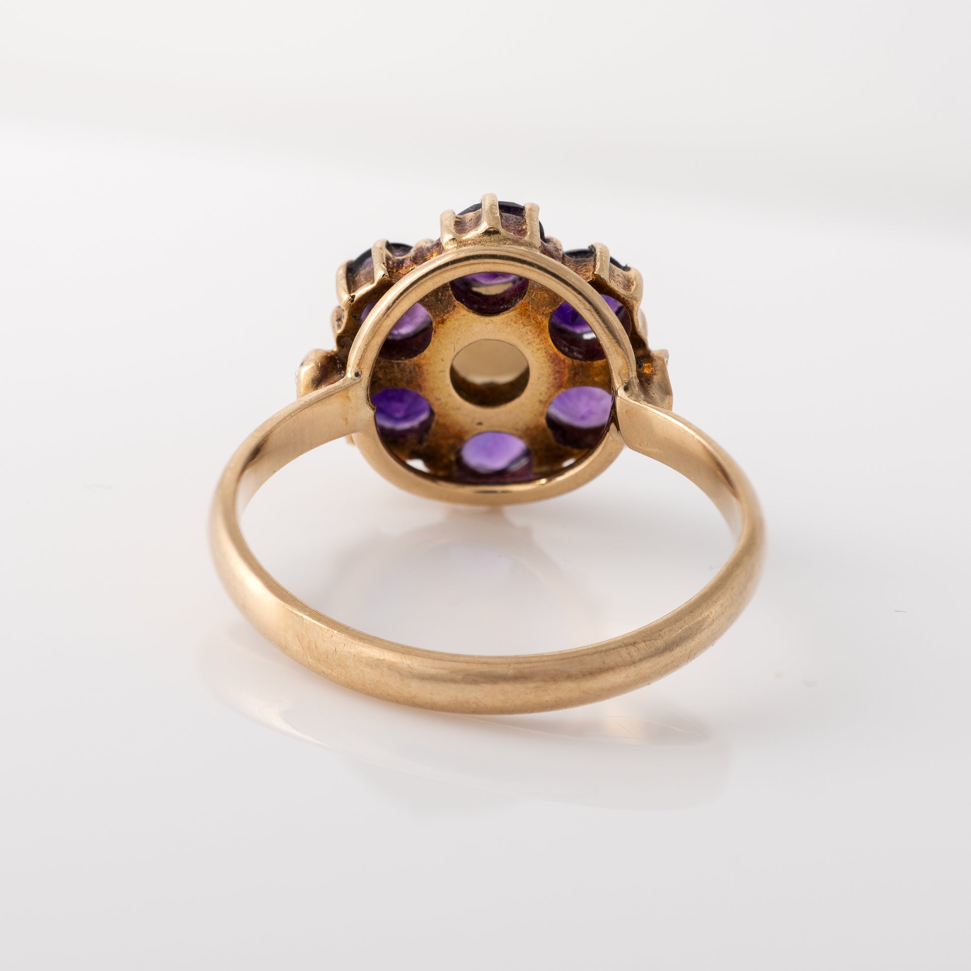 Back view of vintage amethyst and pearl flower ring showing open gold setting