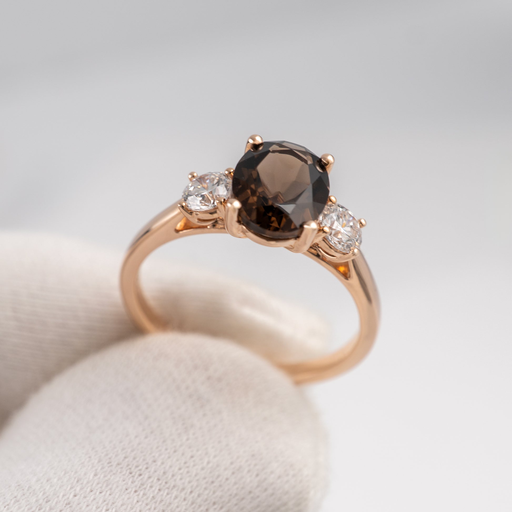 smoky quartz ring with a brown gemstone and two smaller diamonds on a light background