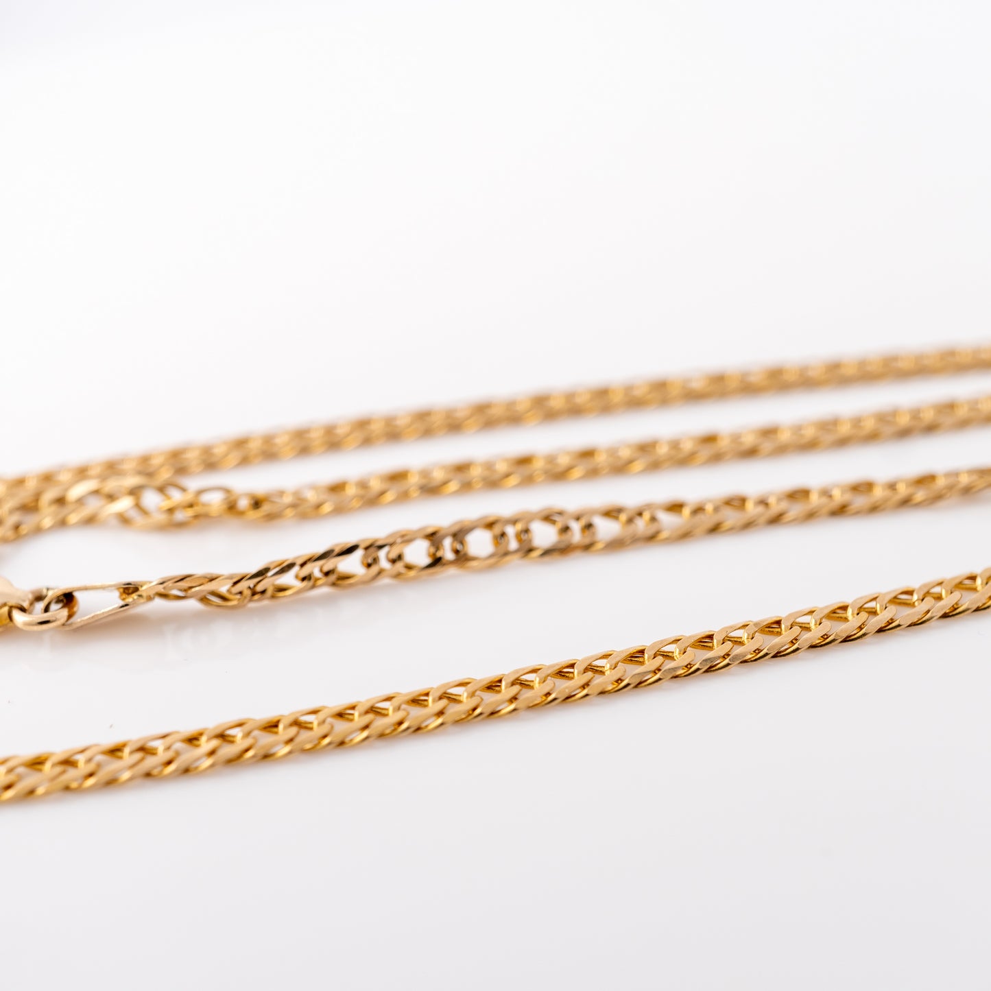 Detailed shot of the 9ct gold flat curb link chain necklace, highlighting the smooth interlocking links