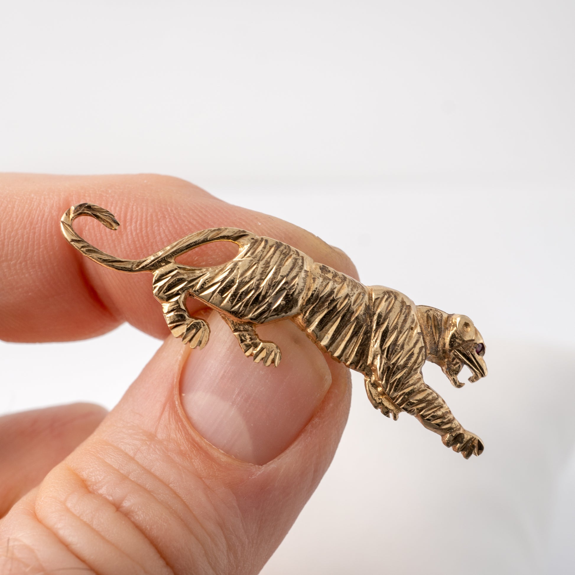 Close-up of gold cat brooch with ruby-set eye