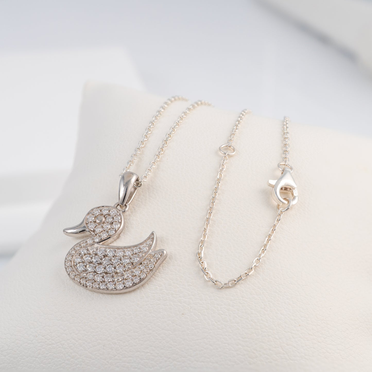 Silver duck necklace pendant with adjustable chain on a white background