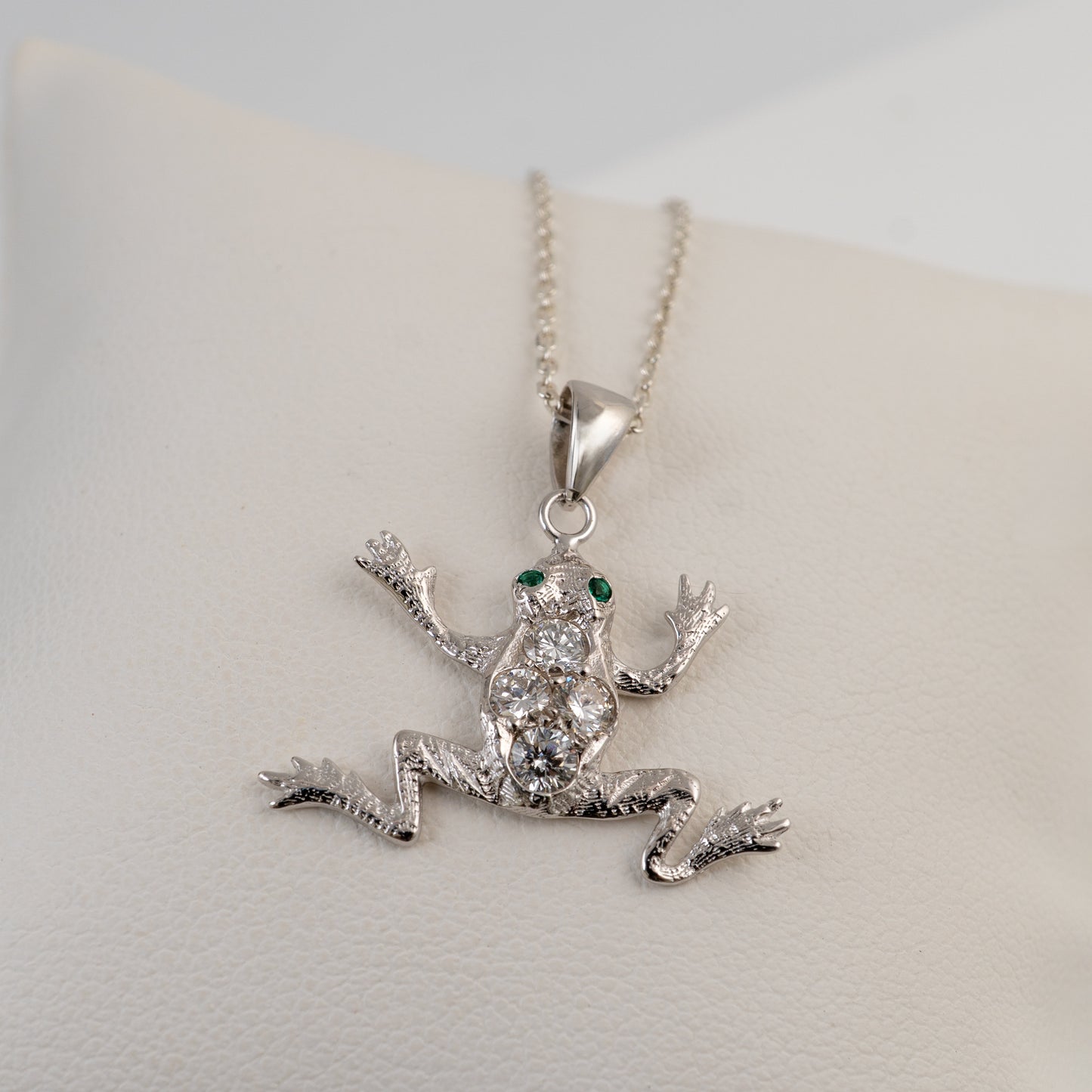 diamond  frog pendant necklace on a light gray background