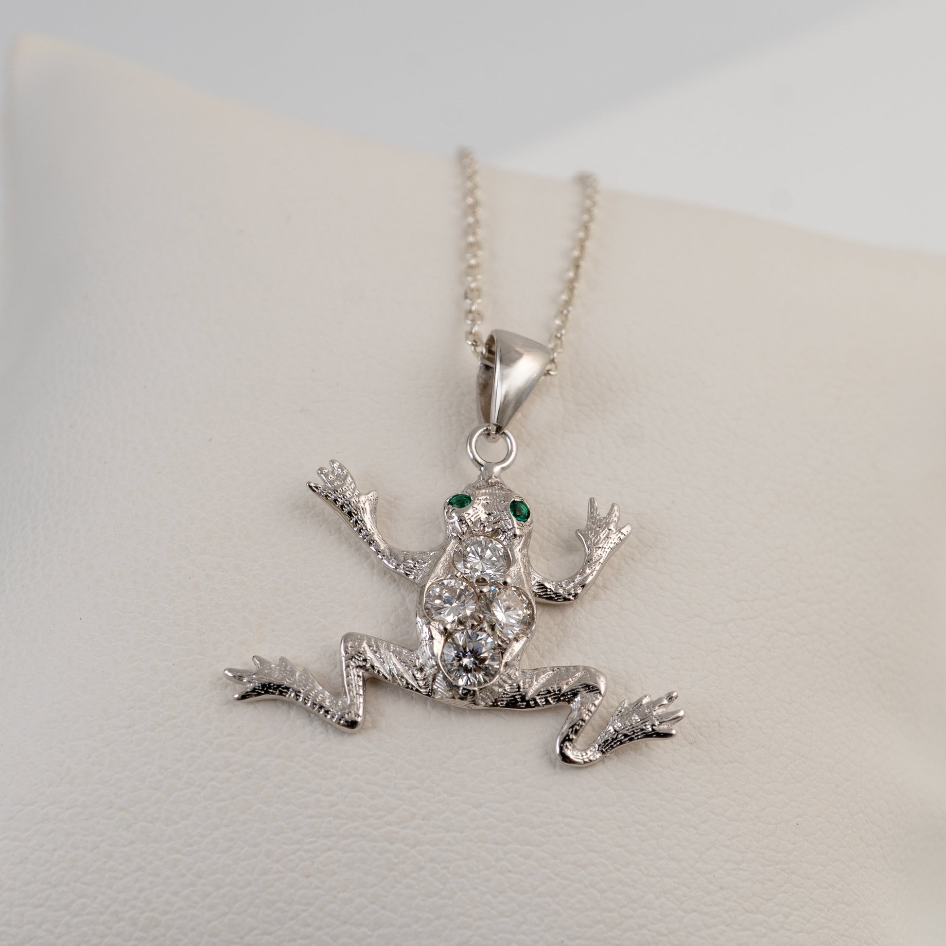 diamond  frog pendant necklace on a light gray background