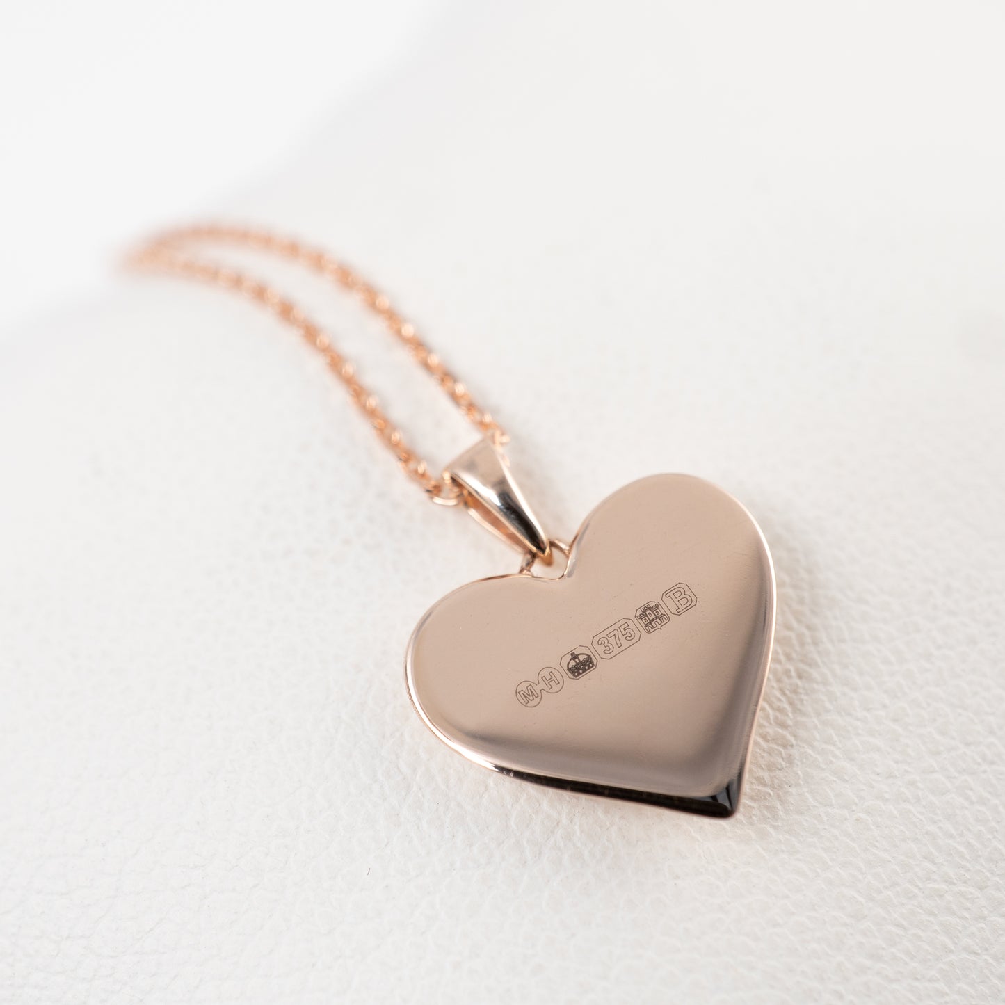 Reverse view of 375 rose gold heart pendant showing smooth flat back and Edinburgh hallmarking