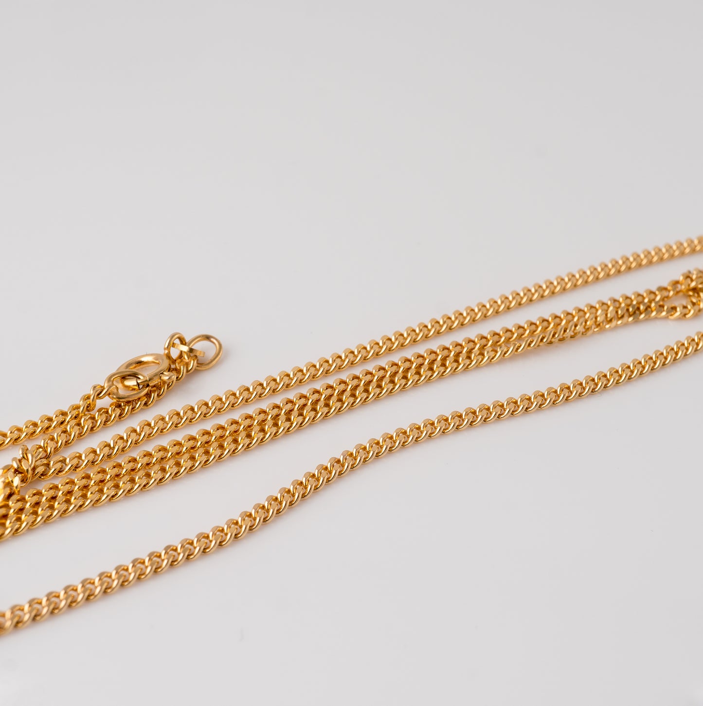 9ct gold flat curb chain necklace laid out, showing clasp and fine link details