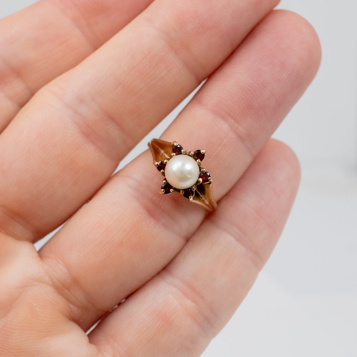 vintage garnet and pearl ring on a hand