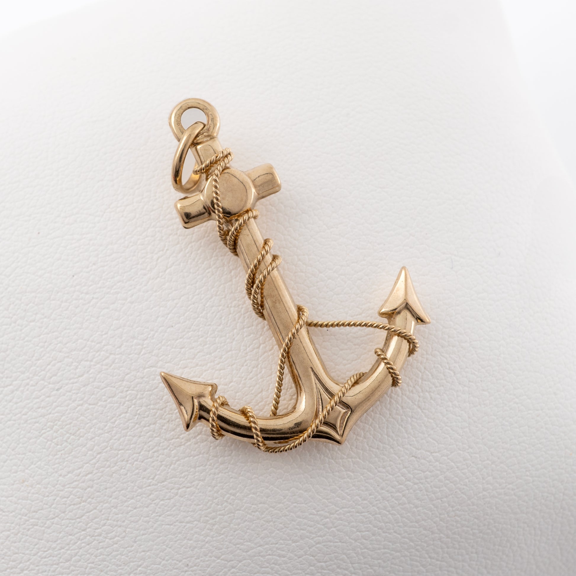 9ct yellow gold anchor pendant with twisted rope detail, displayed on a padded surface for clarity