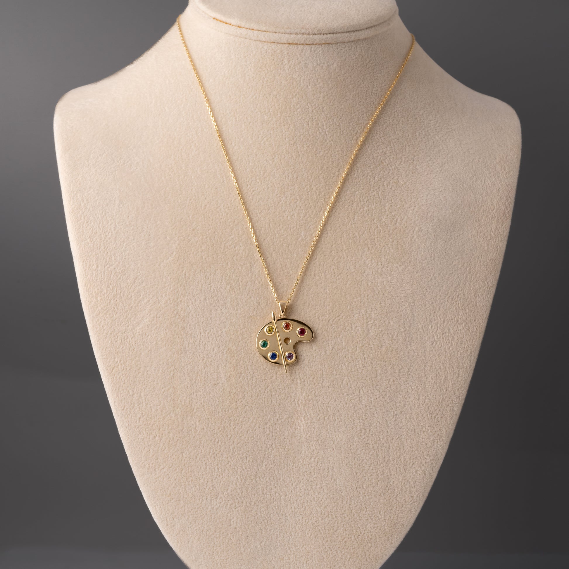 9ct gold artist palette pendant necklace with lab-grown gemstones on a display bust showing scale