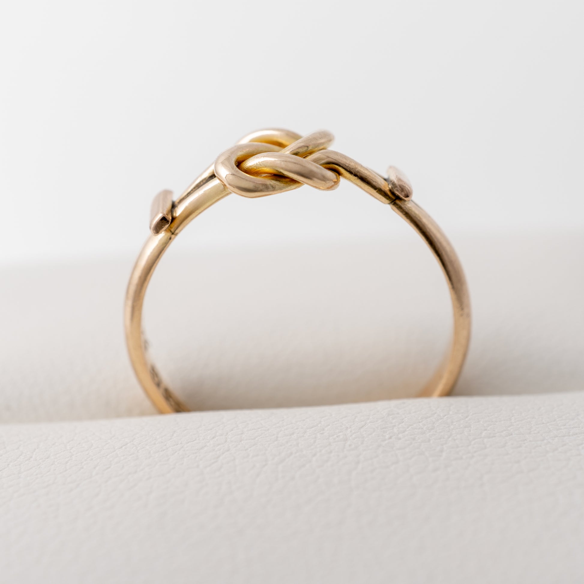 Profile view of antique gold knot ring with setting height