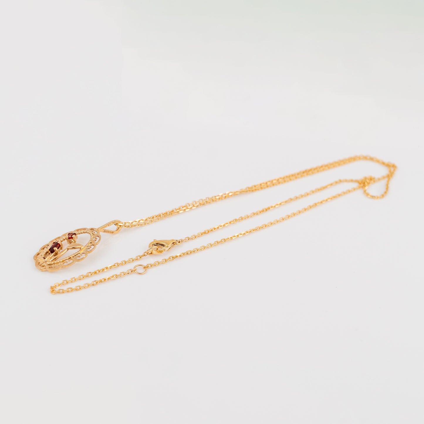 A gold chain necklace with a matching oval pendant featuring a central amber-brown stone, displayed on a clean white background.