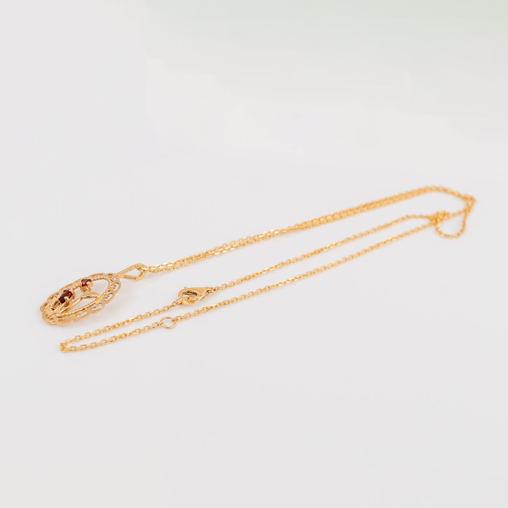 A gold chain necklace with a matching oval pendant featuring a central amber-brown stone, displayed on a clean white background.